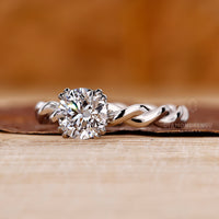 Twisted band ring in white gold with round center