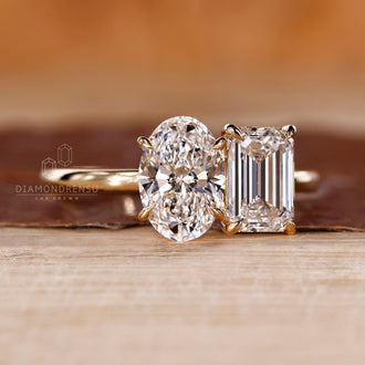 Yellow gold ring with oval and emerald diamonds in claw prong setting.