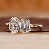 Custom diamond ring with Toi et Moi oval and emerald stones.