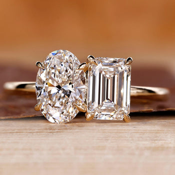 Toi et Moi engagement ring with oval and emerald diamonds in yellow gold.