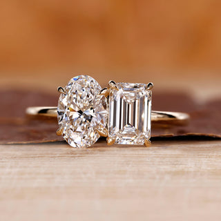 Toi et Moi engagement ring with oval and emerald diamonds in yellow gold.