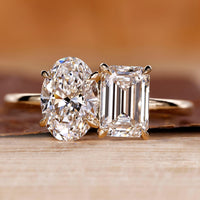 Toi et Moi engagement ring with oval and emerald diamonds in yellow gold.
