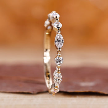 Marquise and round diamond band in a unique half eternity style.