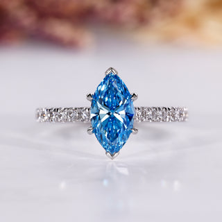 Marquise cut ring with blue diamond and pave setting in white gold.