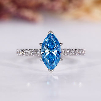 Marquise cut ring with blue diamond and pave setting in white gold.