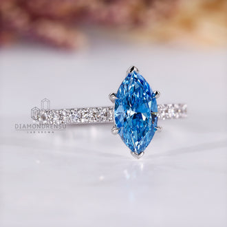 Cathedral setting ring holding blue marquise diamond securely in white gold.