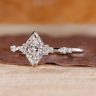 Milgrain ring featuring marquise diamond in cluster engagement design.