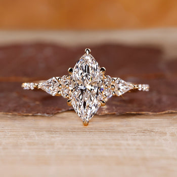Marquise engagement ring with muse setting and kite side diamonds in yellow gold.
