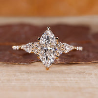 Marquise engagement ring with muse setting and kite side diamonds in yellow gold.