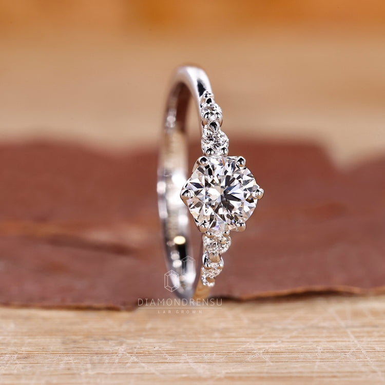 Round cut side stones set in a diamond ring with tapered shank band and IGI certified lab grown diamond.