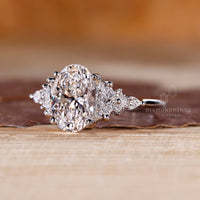 White gold engagement ring with prong setting and oval cut center diamond.
