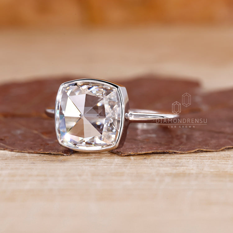 Solitaire ring with cushion cut diamond and handmade detailing.
