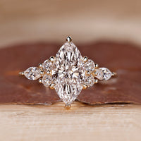 Marquise cut diamond engagement ring with muse setting and round side stones.