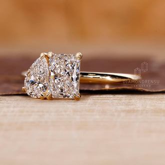 2 stone diamond ring with radiant and pear cut diamonds in yellow gold.