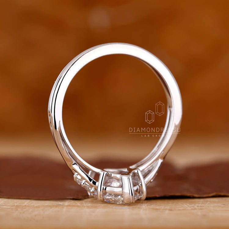 Four round prong ring featuring marquise cut diamond and custom design.
