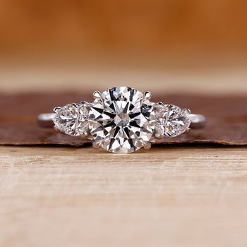 Three stone diamond ring with two pear side stones in white gold.