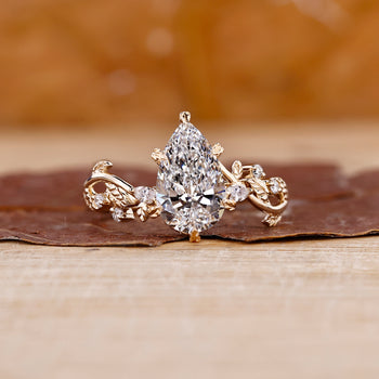 Pear shaped diamond engagement ring in a floral design setting.