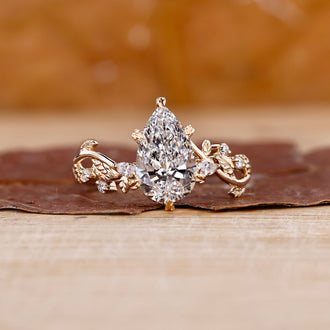 Pear shaped diamond engagement ring in a floral design setting.