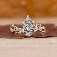 Pear shaped diamond engagement ring in a floral design setting.