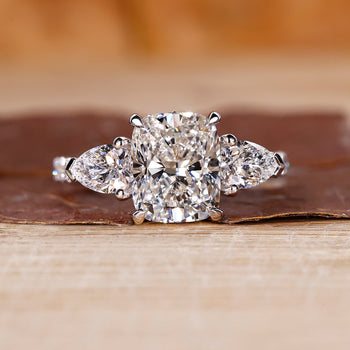 Cushion cut hidden halo engagement ring with lab grown diamond center.