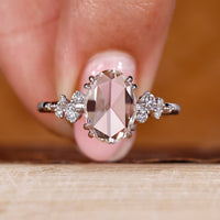 Oval rose cut diamond ring with cluster diamond design in white gold.