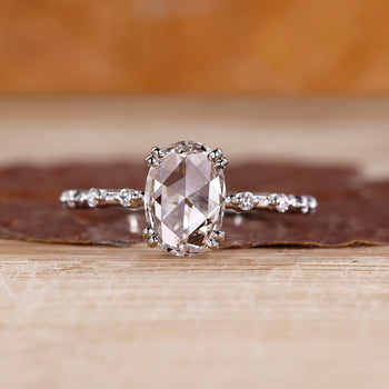 Oval rose cut diamond ring with distance pave setting in white gold.