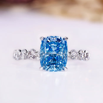 Blue diamond ring with cushion cut in white gold setting.