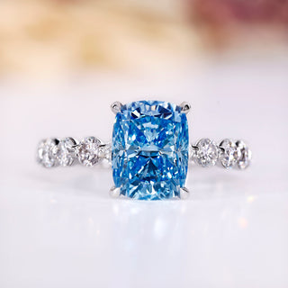 Blue diamond ring with cushion cut in white gold setting.
