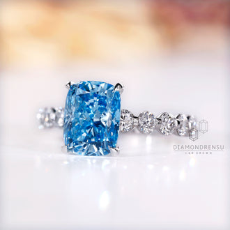 Custom diamond ring featuring blue cushion cut and handmade jewelry.