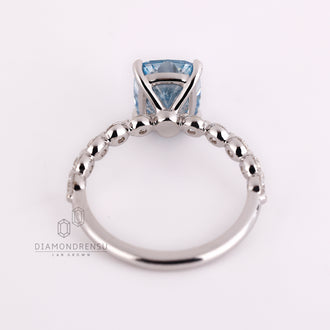 Handmade jewelry ring with blue cushion cut and white gold band.