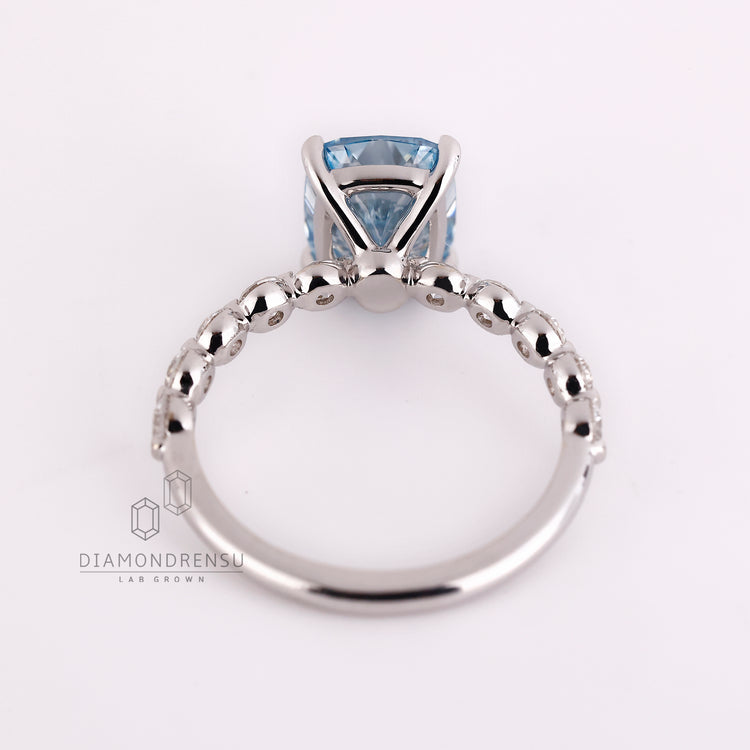 Handmade jewelry ring with blue cushion cut and white gold band.
