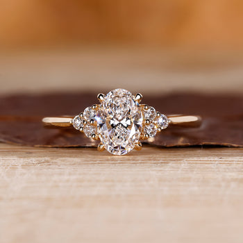 Oval center diamond ring with round side diamonds.