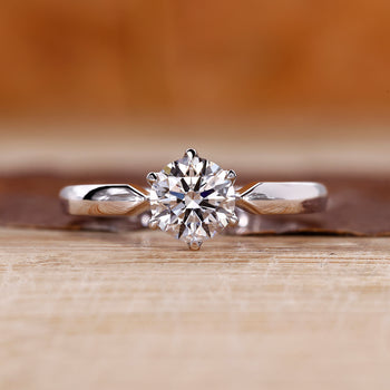 Round diamond solitaire engagement ring with tapered shank and six claw prong.