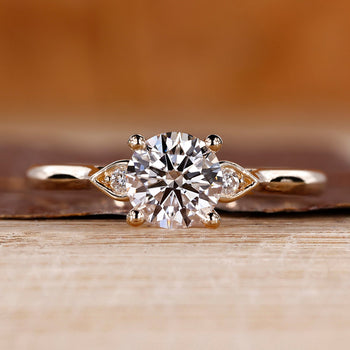 3 stone round diamond ring with cathedral setting and pear shape outline.