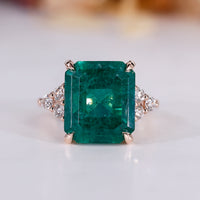 Emerald gemstone ring in rose gold setting.