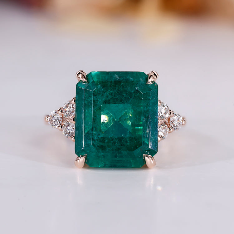 Emerald gemstone ring in rose gold setting.