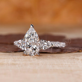 Cathedral setting ring featuring pear cut diamond and custom handmade design.