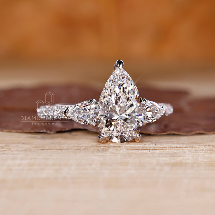 3 side pave setting ring with pear cut diamond and handmade jewelry.