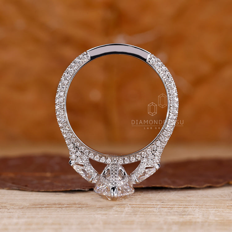 Custom diamond ring with pear cut diamond and 3 side pave setting.