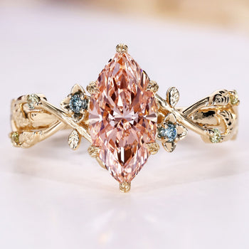 Marquise diamond ring with pink center diamond and blue sides.