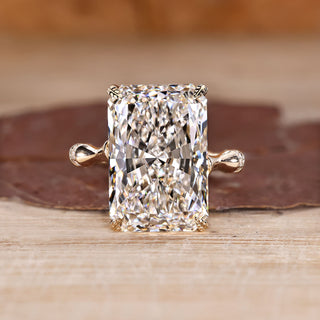 Radiant cut diamond ring with round diamond distance pave band.