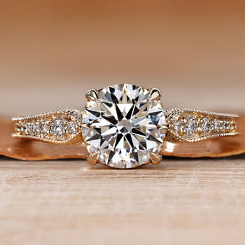 Round cut diamond ring with pave style and filigree details.