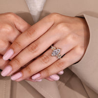 Marquise cut ring with round side stones and claw prong setting.