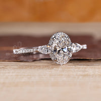 Oval diamond ring with pear sides and cathedral setting.