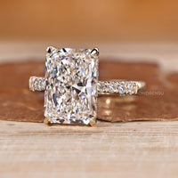 Radiant engagement ring with hidden halo with round stones.