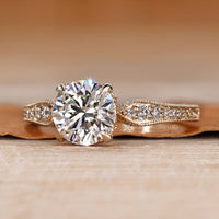 Round cut diamond ring with filigree and milgrain details.