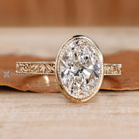 Handmade oval diamond ring with milgrain details.