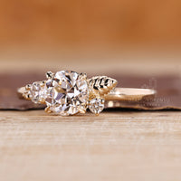 Nature inspired three stone ring with round side diamonds.
