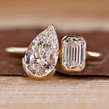 Toi et moi ring pear emerald diamonds cathedral setting.