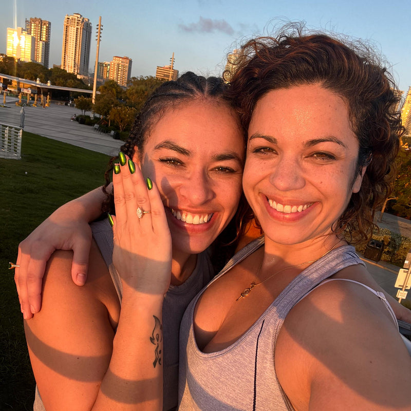 Smiling man and woman hugging at sunset showing an engagement ring Smiling man and woman hugging at sunset showing an engagement ring